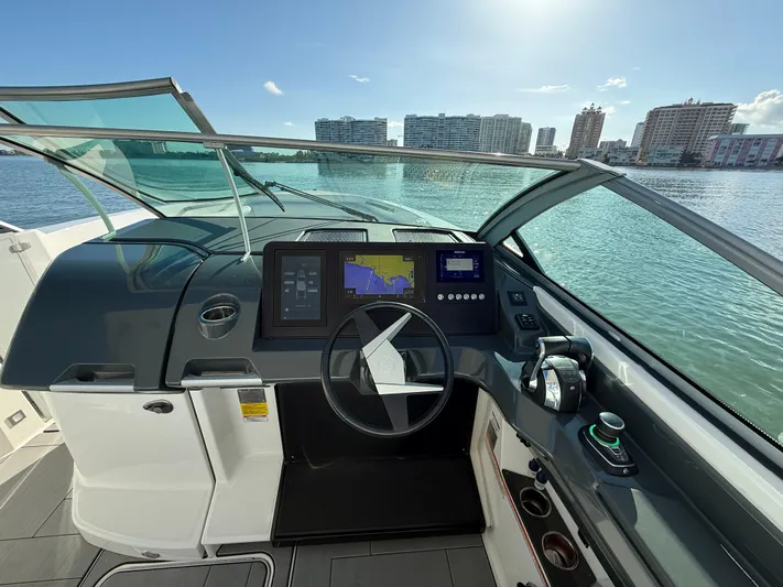  Yacht Photos Pics 2021 Aviara AV32 OB boat helm with navigation screens, steering wheel, and waterfront view.