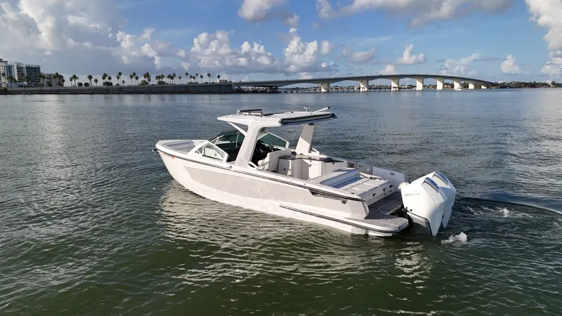  Yacht Photos Pics 2021 Aviara AV32 OB boat cruising on calm waters near a bridge.