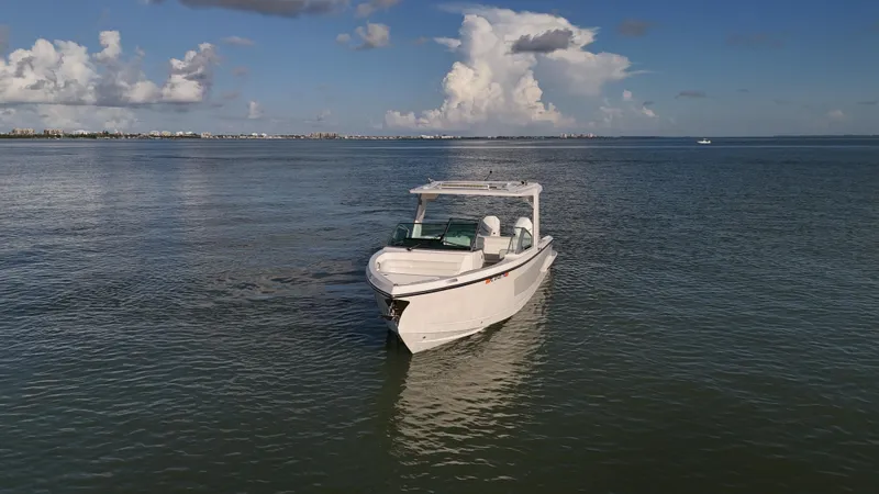  Yacht Photos Pics 2021 Aviara AV32 OB boat on calm water under a partly cloudy sky.