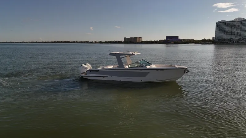  Yacht Photos Pics 2021 Aviara AV32 OB boat cruising on calm waters near modern buildings.