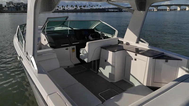  Yacht Photos Pics 2021 Aviara AV32 OB luxury boat interior with seating and helm, docked on calm water.