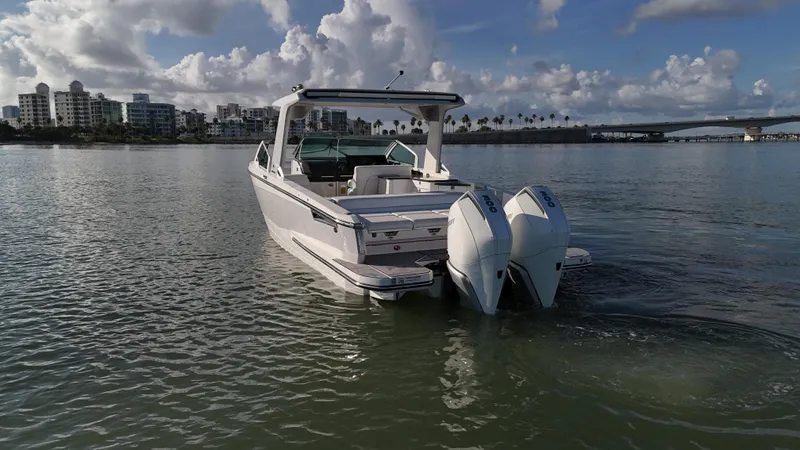  Yacht Photos Pics 2021 Aviara AV32 OB boat on calm water with cityscape and bridge in background.