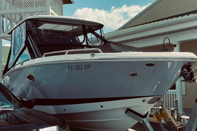  Yacht Photos Pics 2022 Chaparral 280 OSX boat docked near a building under a clear sky.