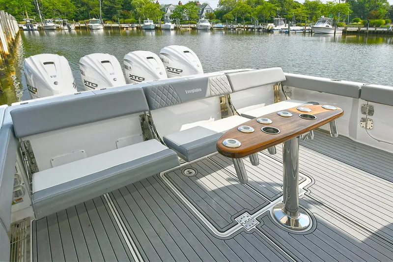 Fourtuna 2 Yacht Photos Pics 2023 Everglades 455 Center Console boat with seating and table, docked by a serene lake.