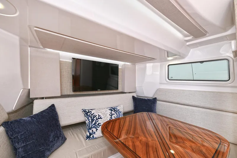 Fourtuna 2 Yacht Photos Pics Luxurious interior of 2023 Everglades 455 Center Console with elegant wood table and plush seating.