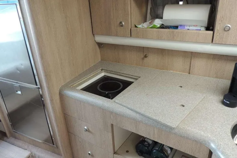  Yacht Photos Pics Compact kitchen area in a 2001 Formula 400 Super Sport boat, featuring a stove and storage.