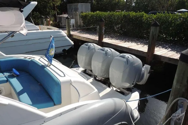  Yacht Photos Pics 2001 Formula 400 Super Sport boat with triple outboard engines docked by a wooden pier.
