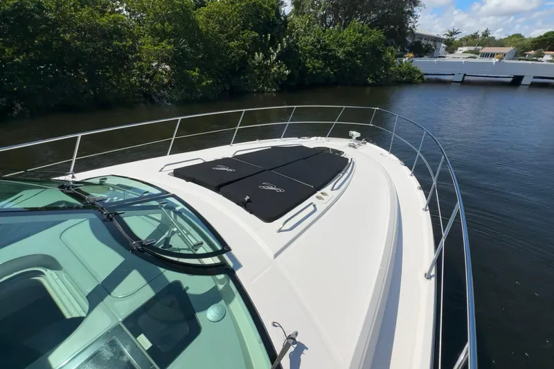  Yacht Photos Pics 2012 Sea Ray 470 Sundancer yacht on calm water, featuring sleek design and sunbathing area.