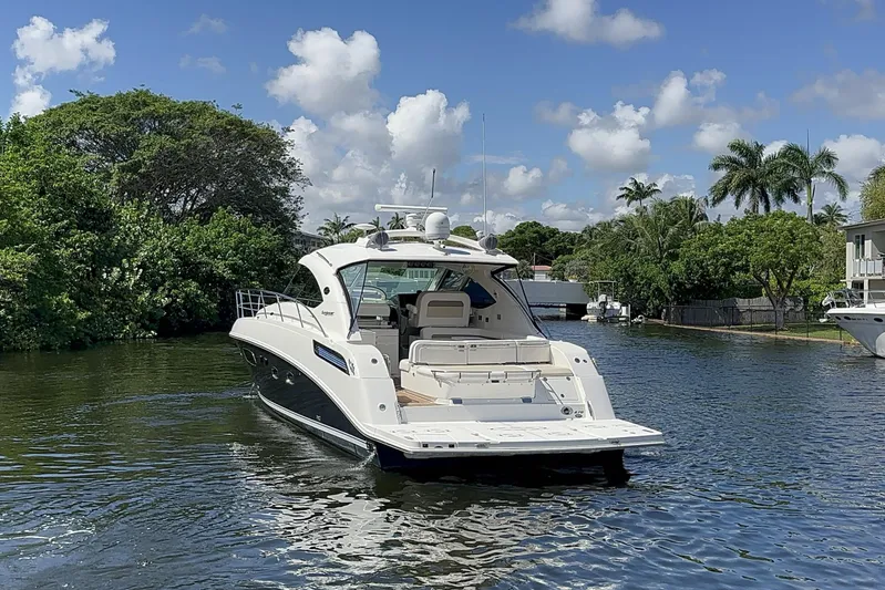  Yacht Photos Pics 2012 Sea Ray 470 Sundancer yacht cruising on a scenic waterway with lush greenery.