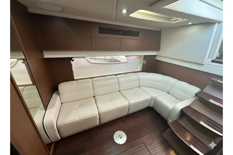  Yacht Photos Pics Luxurious interior of 2012 Sea Ray 470 Sundancer with white leather seating and wooden accents.