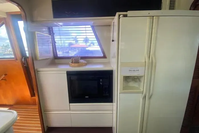 Sea Sharp Yacht Photos Pics Interior of 1990 Viking Motor Yacht kitchen with fridge, microwave, and window view.