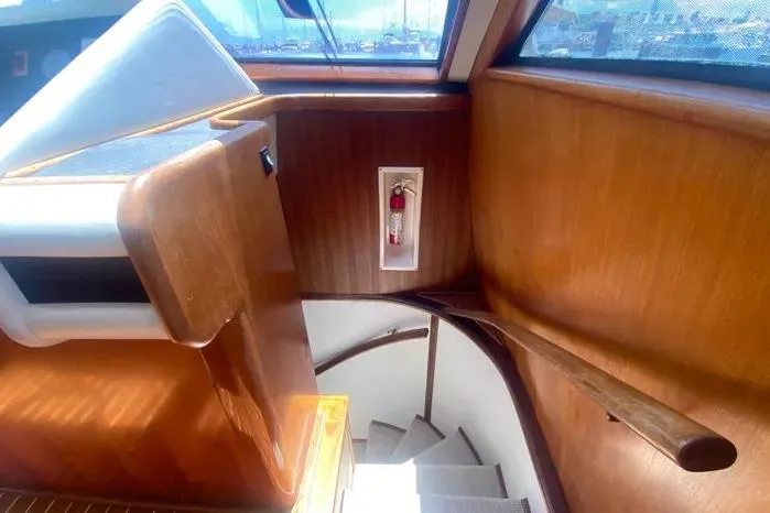 Sea Sharp Yacht Photos Pics Interior staircase of a 1990 Viking Motor Yacht with wooden paneling and a fire extinguisher.