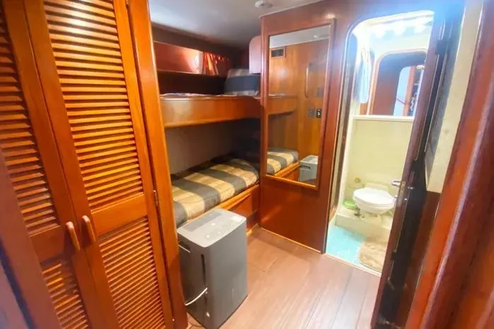 Sea Sharp Yacht Photos Pics 1990 Viking Motor Yacht interior with bunk beds, wooden cabinetry, and bathroom.
