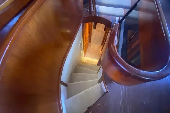 Sea Sharp Yacht Photos Pics Curved wooden staircase inside 1990 Viking Motor Yacht, leading to lower deck.