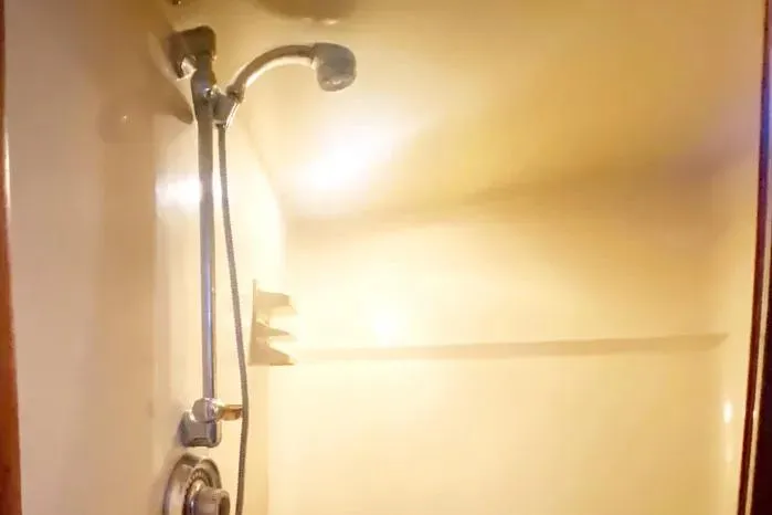 Sea Sharp Yacht Photos Pics Shower area inside a 1990 Viking Motor Yacht, featuring a chrome showerhead and light.