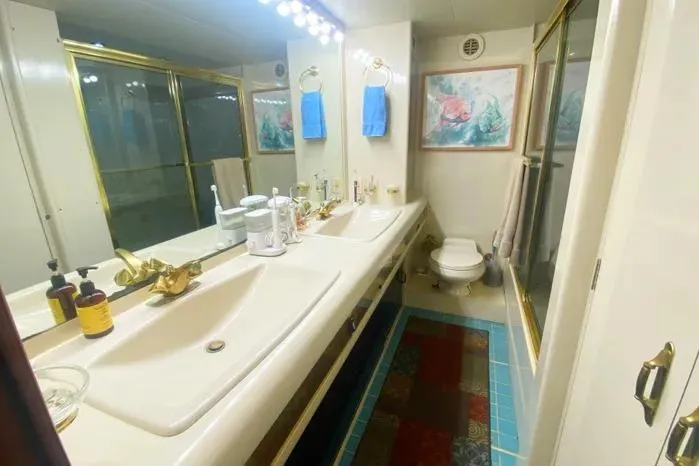 Sea Sharp Yacht Photos Pics Luxurious 1990 Viking Motor Yacht bathroom with double sinks, gold fixtures, and elegant decor.