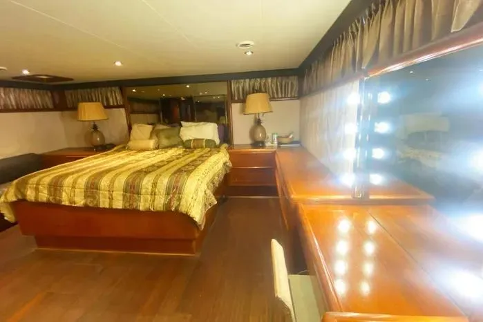 Sea Sharp Yacht Photos Pics Luxurious bedroom interior of a 1990 Viking Motor Yacht with elegant wood furnishings.