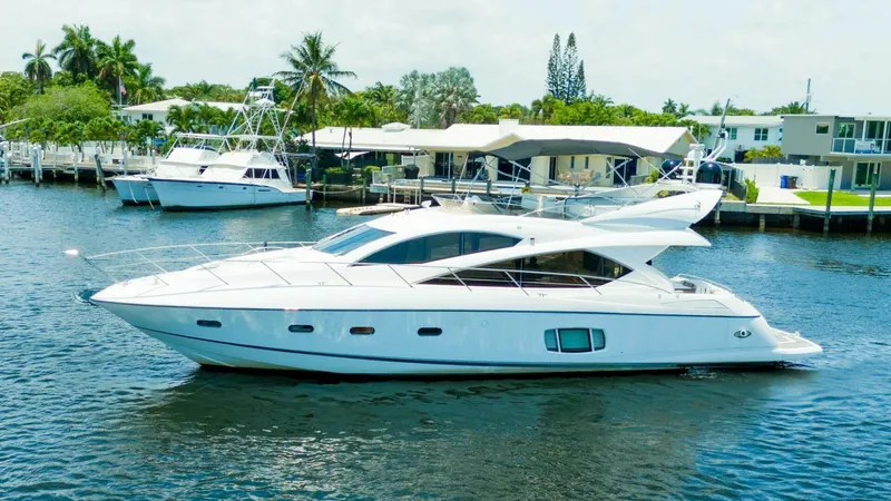 Currency Yacht Photos Pics 2009 Sunseeker 60 Manhattan yacht cruising on a serene waterway.