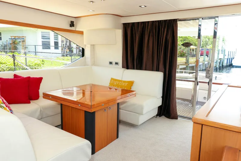 Currency Yacht Photos Pics Luxurious interior of 2009 Sunseeker 60 Manhattan yacht with elegant seating and wooden table.