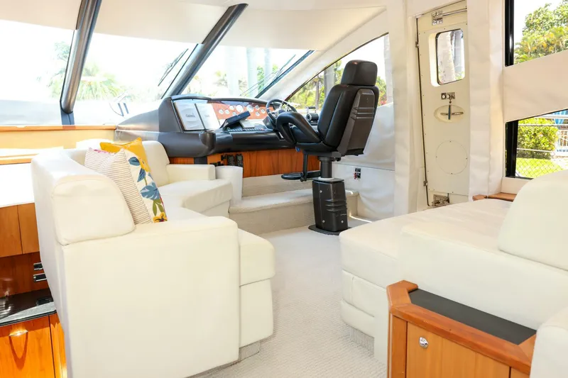 Currency Yacht Photos Pics Luxurious interior of 2009 Sunseeker 60 Manhattan yacht with plush seating and modern helm.