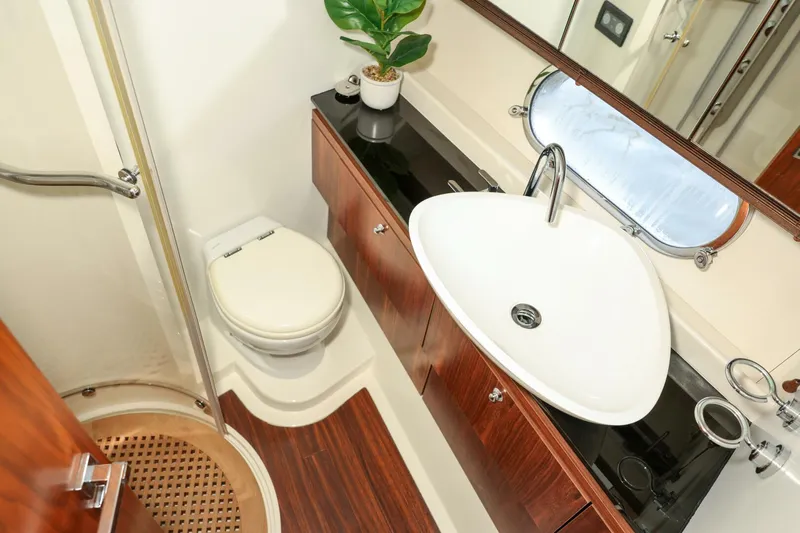 Currency Yacht Photos Pics Luxurious bathroom in 2009 Sunseeker 60 Manhattan yacht with modern fixtures and wood accents.