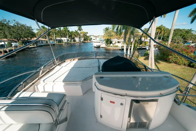 Currency Yacht Photos Pics 2009 Sunseeker 60 Manhattan yacht, spacious deck, canal view, palm trees, luxury boating experience.