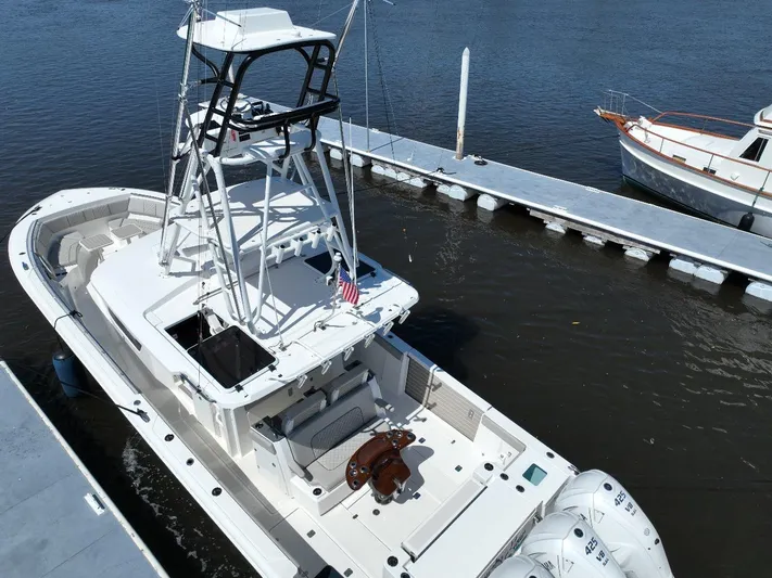 Happy Hour Yacht Photos Pics 2022 Pursuit s428 boat docked at marina, featuring a spacious deck and tower.