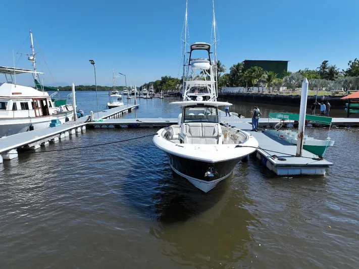 Happy Hour Yacht Photos Pics 2022 Pursuit s428 boat docked at a marina under clear blue skies.