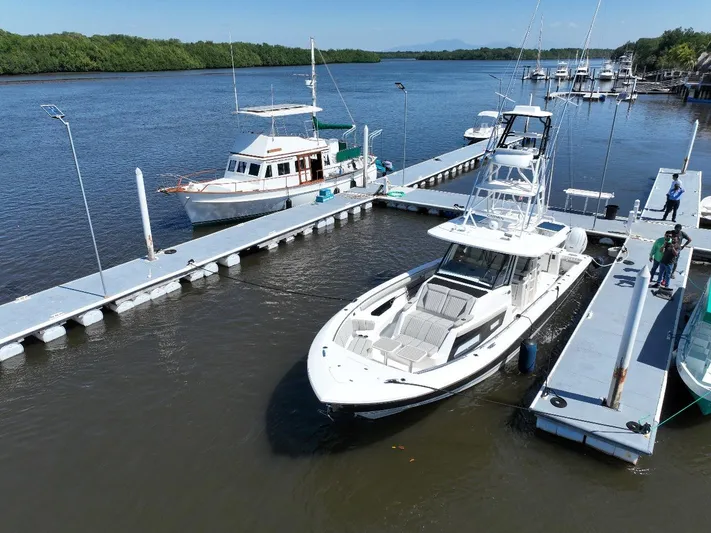 Happy Hour Yacht Photos Pics 2022 Pursuit s428 boat docked at marina with scenic river backdrop.