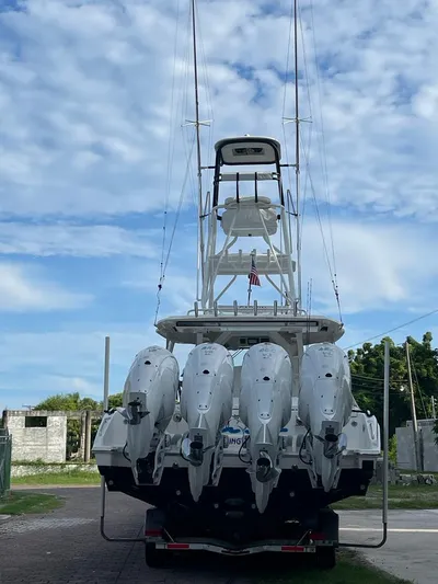Happy Hour Yacht Photos Pics 2022 Pursuit s428 boat with multiple outboard engines, parked on a trailer under a cloudy sky.