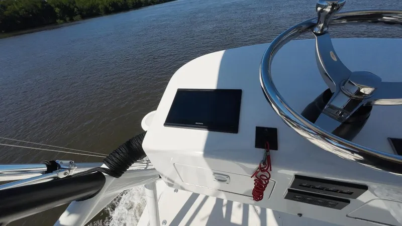 Happy Hour Yacht Photos Pics Helm of 2022 Pursuit s428 boat with steering wheel and control panel on a river.