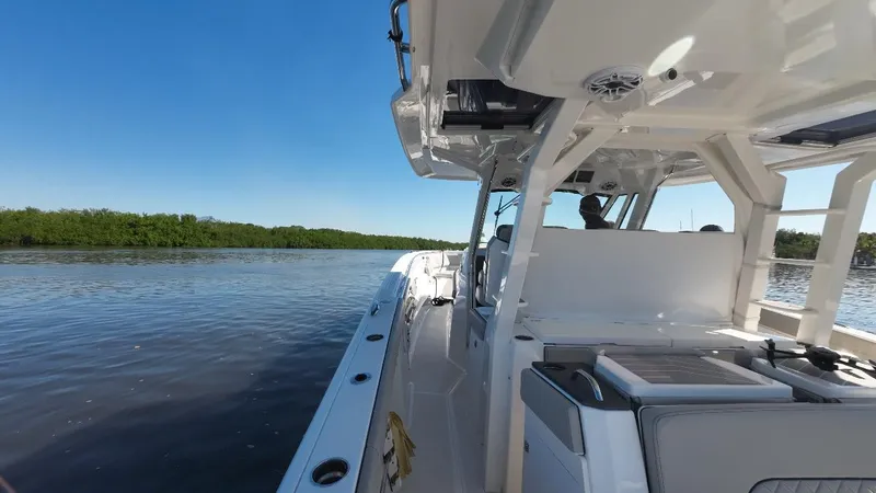 Happy Hour Yacht Photos Pics 2022 Pursuit s428 boat cruising on a calm river under a clear blue sky.