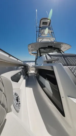 Happy Hour Yacht Photos Pics 2022 Pursuit s428 boat with sleek design, photographed under clear blue sky.