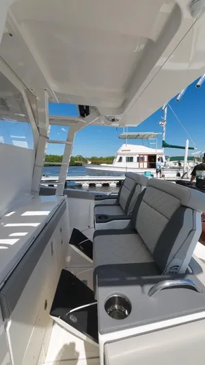 Happy Hour Yacht Photos Pics 2022 Pursuit s428 boat interior with gray seating and cup holders, docked under clear blue sky.