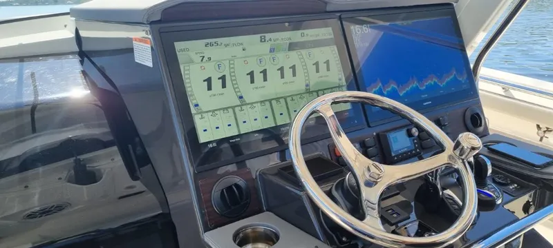 Happy Hour Yacht Photos Pics Control panel of 2022 Pursuit s428 boat with digital displays and steering wheel.