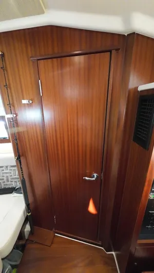 Happy Hour Yacht Photos Pics 2022 Pursuit s428 interior with wooden door and fishing rod holder.
