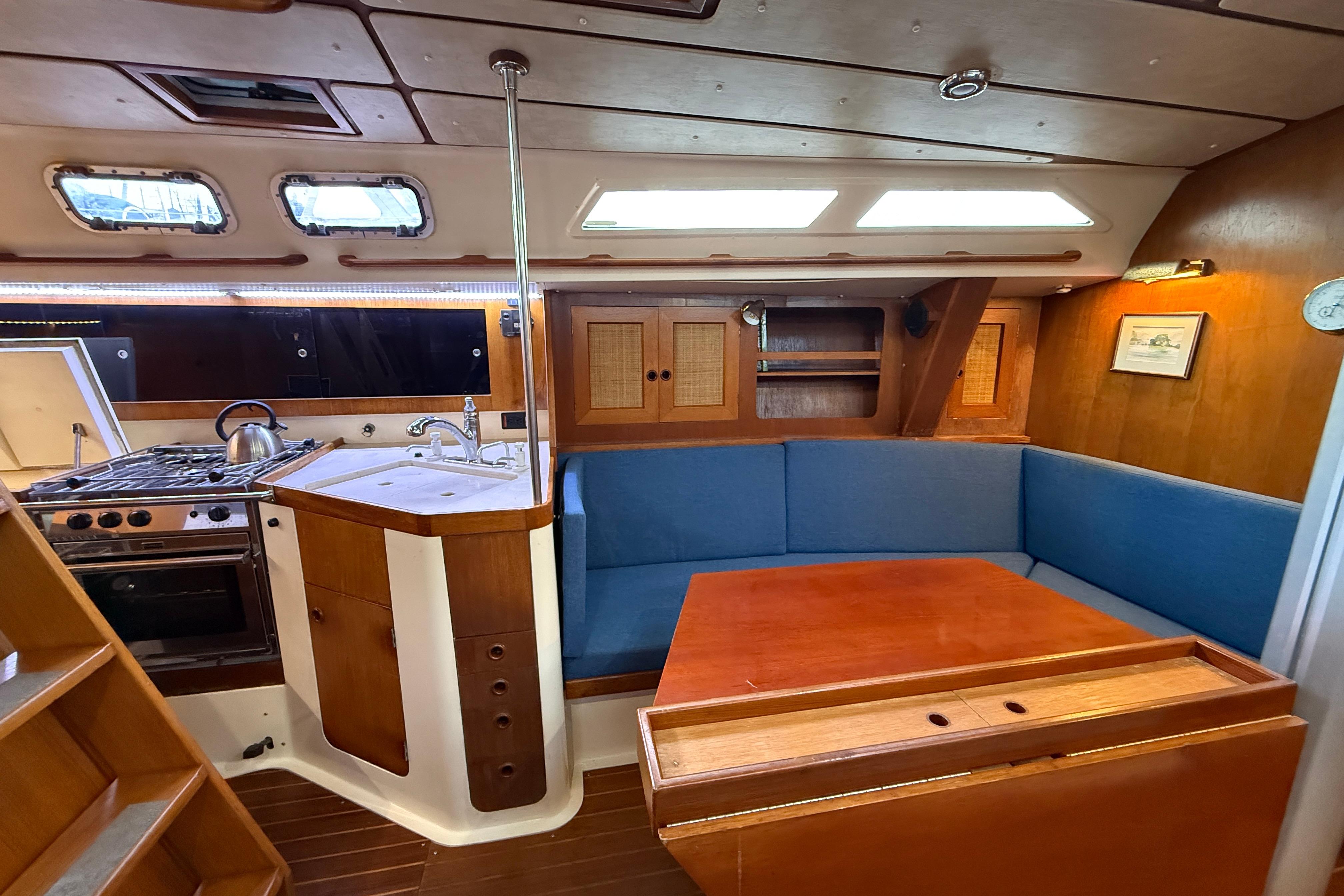 1987 CS 40 yacht interior with kitchen, seating area, and wooden finishes.