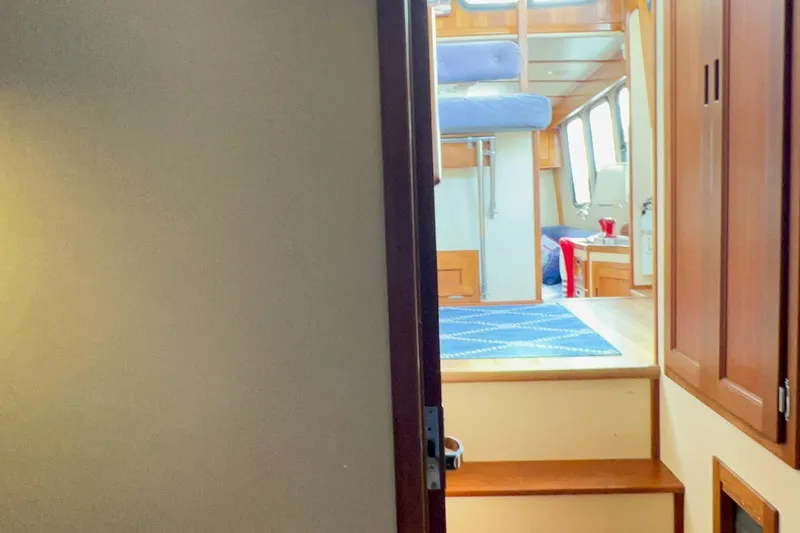 Mirage Yacht Photos Pics Interior view of a 1999 Nordic 32 boat, featuring wooden stairs and cozy cabin space.