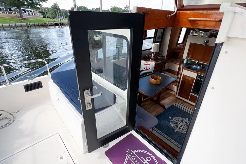 Mirage Yacht Photos Pics Interior view of a 1999 Nordic 32 boat, featuring a cozy cabin and kitchenette.