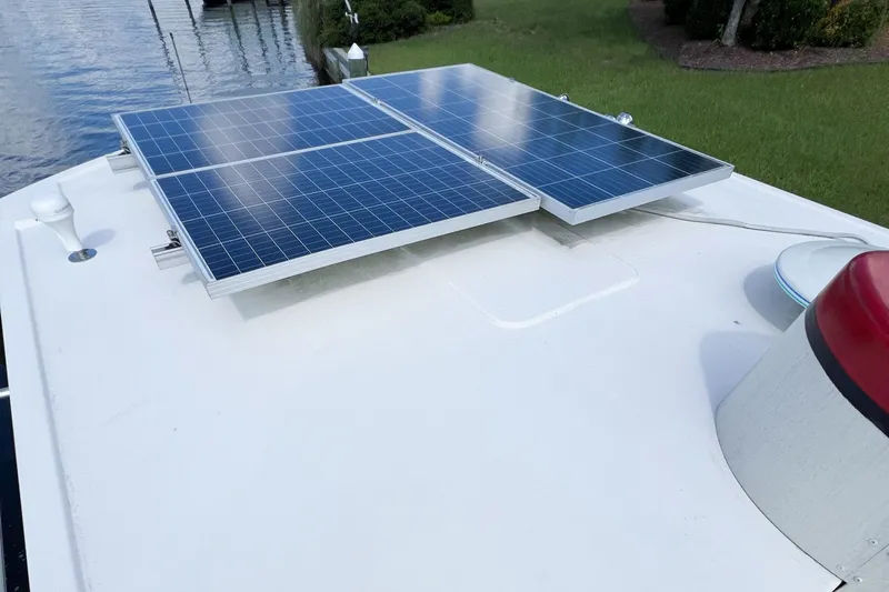 Mirage Yacht Photos Pics Solar panels on a 1999 Nordic 32 boat, docked near grassy shoreline.