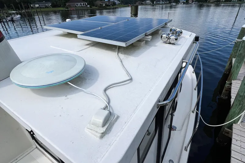 Mirage Yacht Photos Pics Rooftop of 1999 Nordic 32 boat with solar panels and satellite dish by the water.