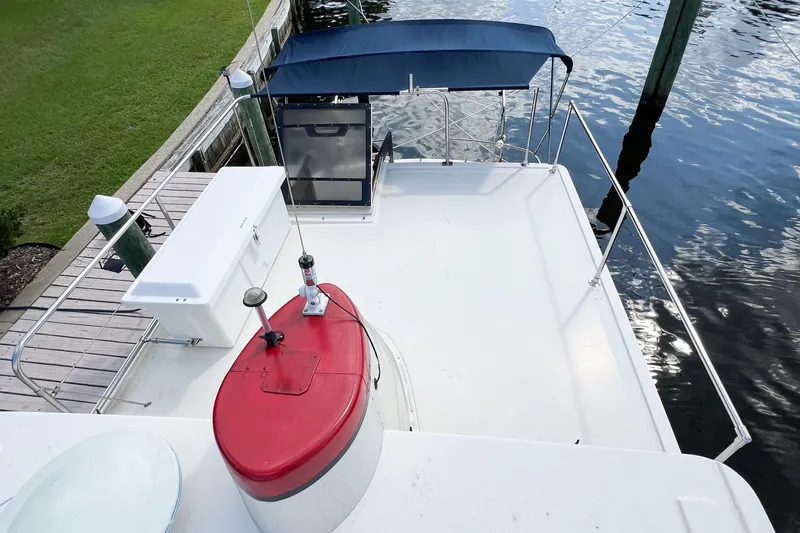 Mirage Yacht Photos Pics Nordic 32 boat deck, 1999 model, docked by water with canopy and equipment.