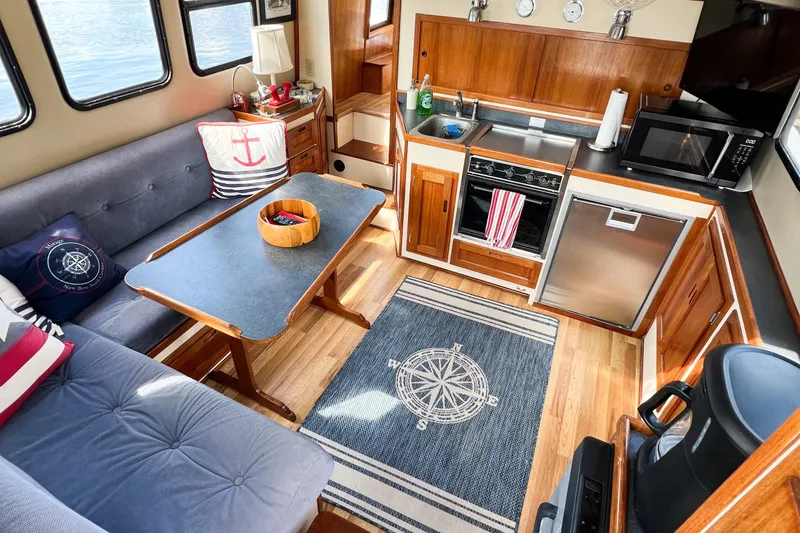 Mirage Yacht Photos Pics Cozy Nordic 32 boat interior with nautical decor, featuring a kitchen and seating area, built in 1999.