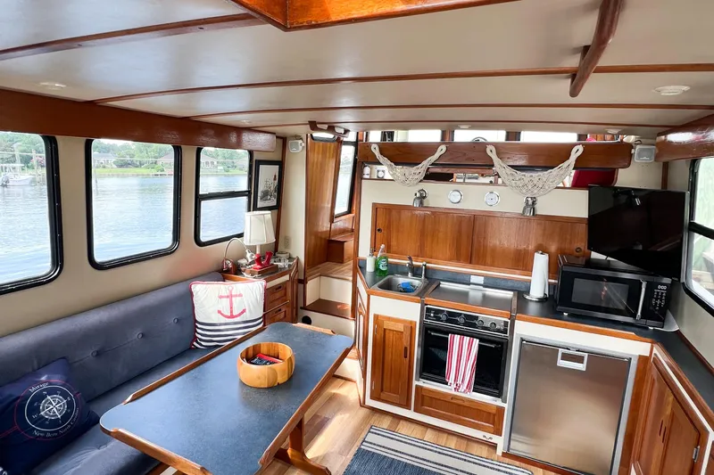Mirage Yacht Photos Pics Cozy interior of a 1999 Nordic 32 boat with kitchen and seating area.