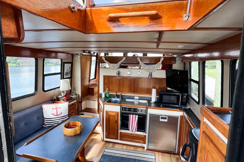 Mirage Yacht Photos Pics Cozy interior of a 1999 Nordic 32 boat with wooden accents and modern amenities.