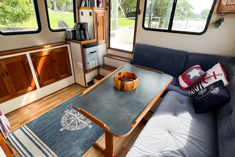 Mirage Yacht Photos Pics Cozy interior of 1999 Nordic 32 boat with wooden cabinets and nautical-themed decor.