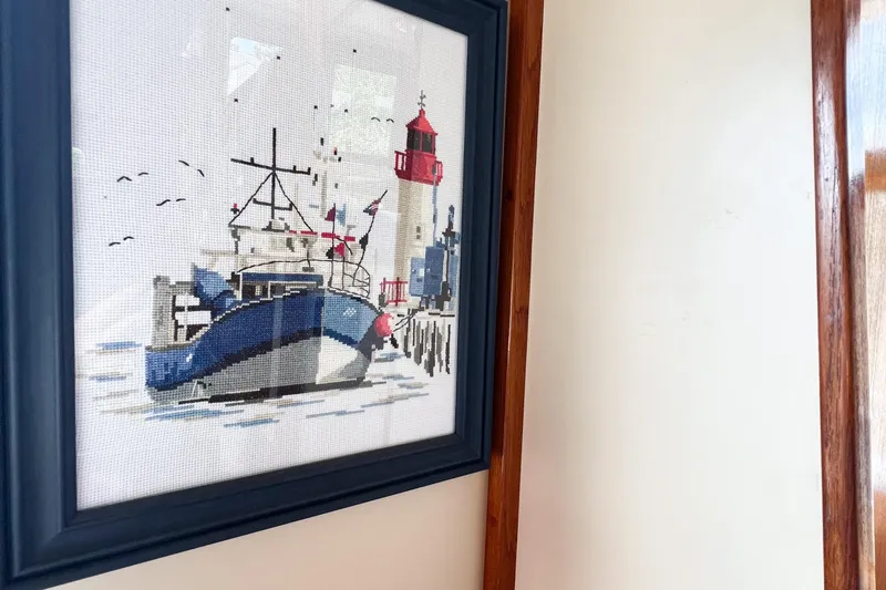 Mirage Yacht Photos Pics Framed nautical cross-stitch art featuring a boat and lighthouse, Nordic model 32, 1999.