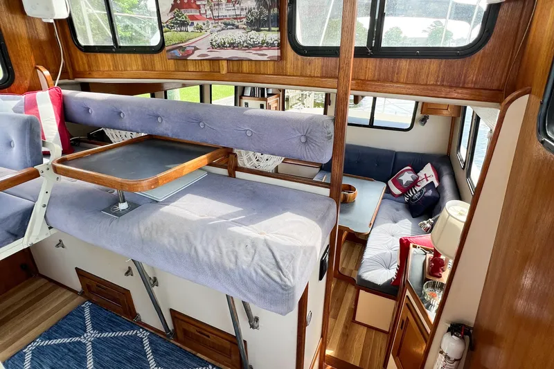 Mirage Yacht Photos Pics Cozy interior of a 1999 Nordic 32 boat with wood accents and cushioned seating.