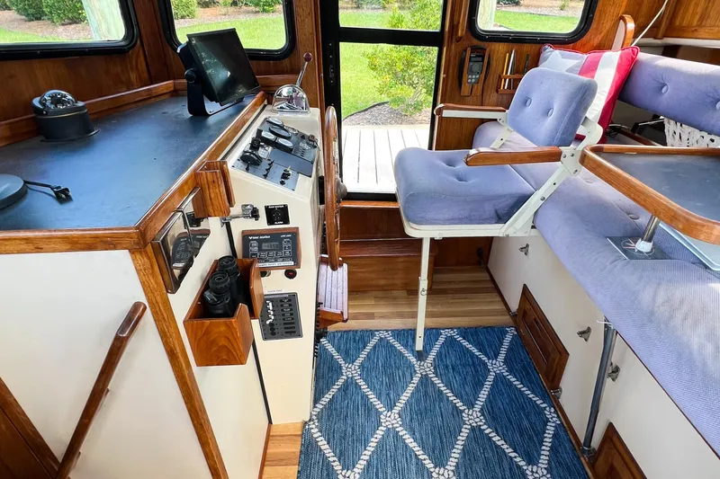 Mirage Yacht Photos Pics Interior of a 1999 Nordic 32 boat with control panel and seating area.