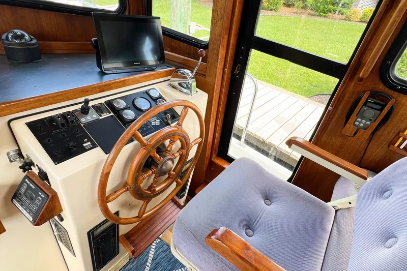 Mirage Yacht Photos Pics Helm of 1999 Nordic 32 boat with wooden steering wheel and navigation equipment.